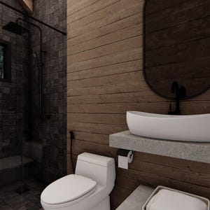 May include: Modern bathroom interior with a dark tiled shower area and a wooden wall. Features a white sink on a concrete shelf, a toilet, and a large oval mirror. The shower has a black shower head and a window with a view of trees.