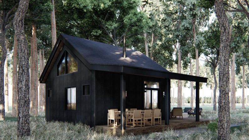 May include: A modern, black cabin nestled in a forest setting. The cabin features a gabled roof, large windows, and a covered porch with outdoor seating. The surrounding trees create a natural, serene environment.