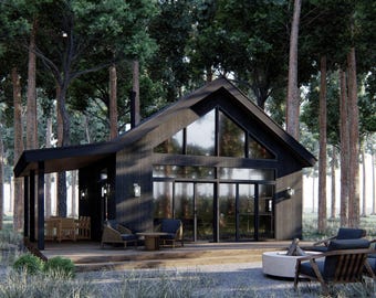Op de afbeelding: Een moderne, zwarte blokhut met grote ramen en een overdekte veranda, genesteld tussen hoge bomen. De hut heeft een zadeldak en een terras met zitplaatsen buiten. Een vuurplaats en ligstoelen staan op de voorgrond en creëren een ontspannende buitenruimte.