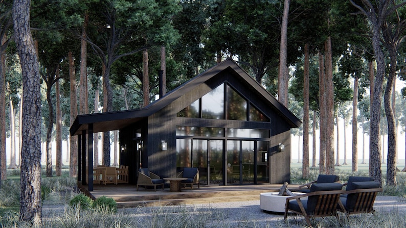 May include: A modern, black cabin with large windows and a covered porch, nestled among tall trees. The cabin features a gabled roof and a deck with outdoor seating. A fire pit and lounge chairs are in the foreground, creating a relaxing outdoor space.