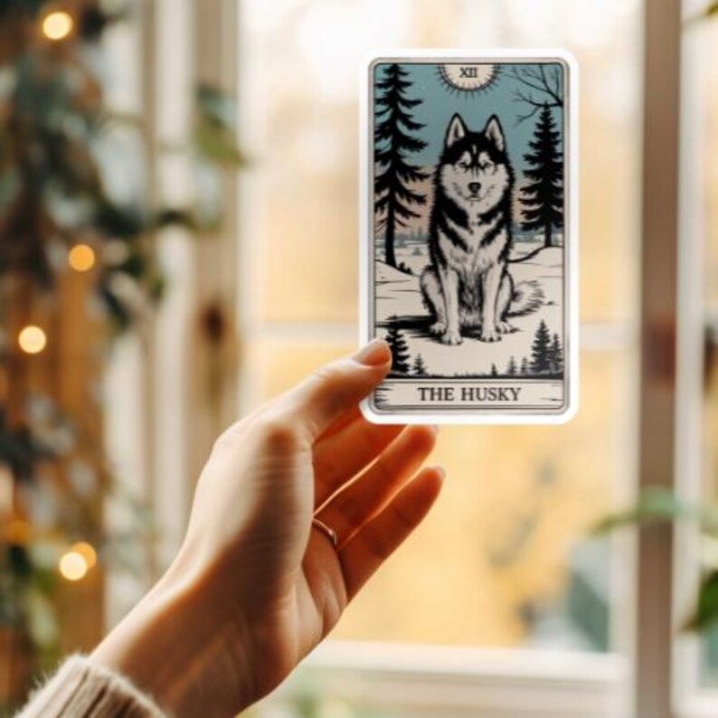 May include: A tarot card with a black and white illustration of a husky dog sitting in a snowy forest. The card is titled "The Husky" and has the number XII on it.