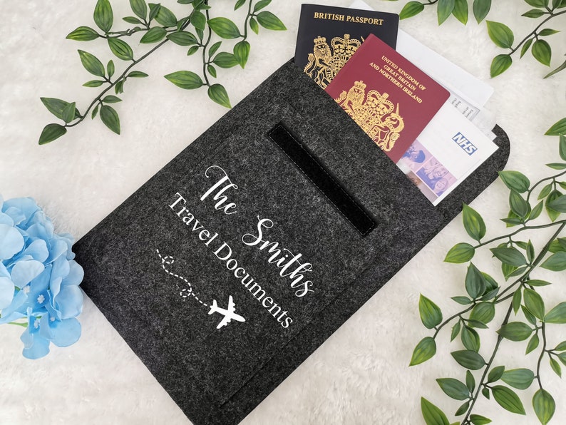 May include: Gray felt travel document holder with a zippered pocket and the text "The Smiths Travel Documents" with a small airplane graphic.