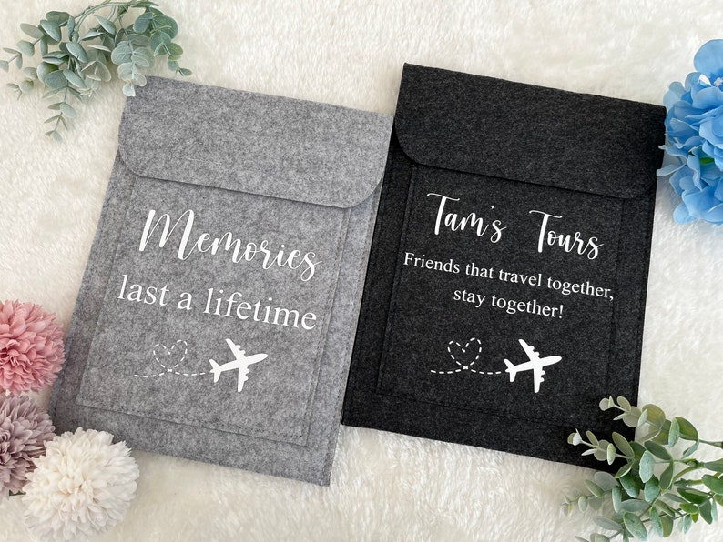 May include: Two gray felt pouches with white text and airplane designs. The pouch on the left says "Memories last a lifetime". The pouch on the right says "Tam's Tours Friends that travel together, stay together!"