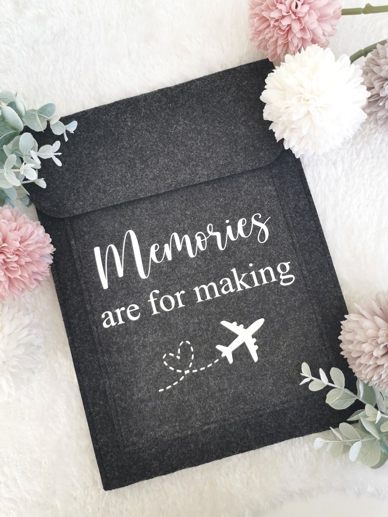 May include: A gray felt pouch with the text "Memories are for making" and a white airplane with a dotted line leading to a heart.