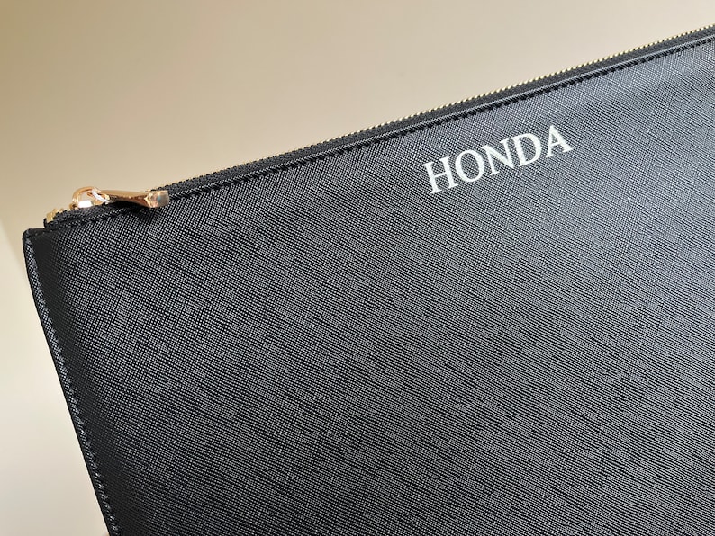 May include: Black zippered pouch with the word "HONDA" printed in white on the front.