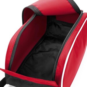 May include: A red and black zipped shoe bag with a wide opening. The exterior is primarily red with a thin white piping detail along the side. The interior is lined with black fabric, and the bag features a black base and black zip tracks.