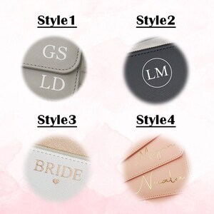 May include: Four different styles of personalized clutches. The first style is gray with the initials "GS" and "LD" in white. The second style is dark gray with the initials "LM" in a white circle. The third style is white with the word "BRIDE" in gold lettering and a small heart. The fourth style is pink with the names "Megan" and "Nuvala" written in gold cursive.
