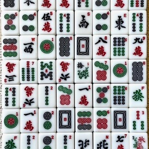 May include: A set of 36 white mahjong tiles with black and green bamboo, circle, and character symbols. The tiles are arranged in a grid pattern and include numbers 1 through 9, wind symbols, and dragon symbols.