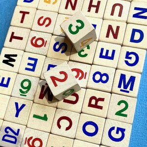 May include: A set of wooden letter and number blocks in various colors. The blocks are arranged in a grid pattern and feature letters, numbers, and the words "WD4" and "D2".