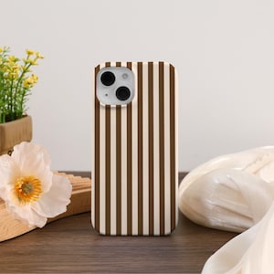 May include: A brown and white striped phone case for an iPhone.