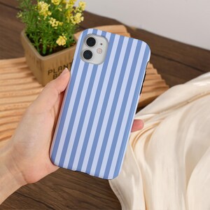 May include: A blue and white striped phone case with a camera cutout. The case is made of a hard plastic material.