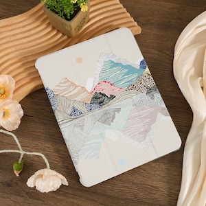Puede incluir: Una funda para tablet blanca con un diseño abstracto de paisaje de montaña colorido. El diseño presenta una variedad de colores, incluyendo azul, verde, rosa y marrón. La funda está hecha de un material duradero y está diseñada para proteger tu tablet de arañazos y golpes.