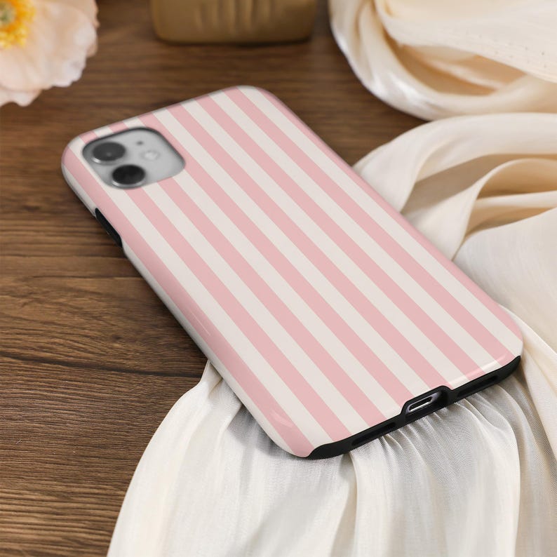 May include: A pink and white striped phone case with a camera cutout.