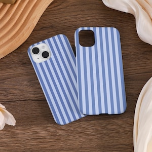 May include: Two blue and white striped phone cases for an iPhone. The cases are made of a hard plastic material and have a smooth finish.