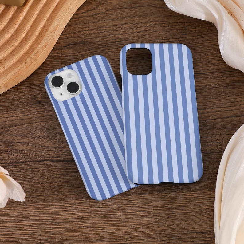 May include: Two blue and white striped phone cases for an iPhone. The cases are made of a hard plastic material and have a smooth finish.