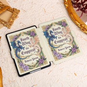 May include: A white and gold e-reader case with a floral design and two dragons. The text on the case reads "Fourth Wing The Empyrean" and "Rebecca Yarros".