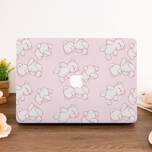May include: Pink laptop skin with a repeating pattern of white teddy bears.