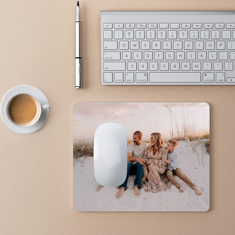 Peut inclure: Un tapis de souris blanc avec une photo d'une famille de trois personnes sur une plage. La famille est assise sur le sable, et le soleil se couche &agrave; l'horizon. Le tapis de souris est un excellent moyen de personnaliser votre espace de travail.
