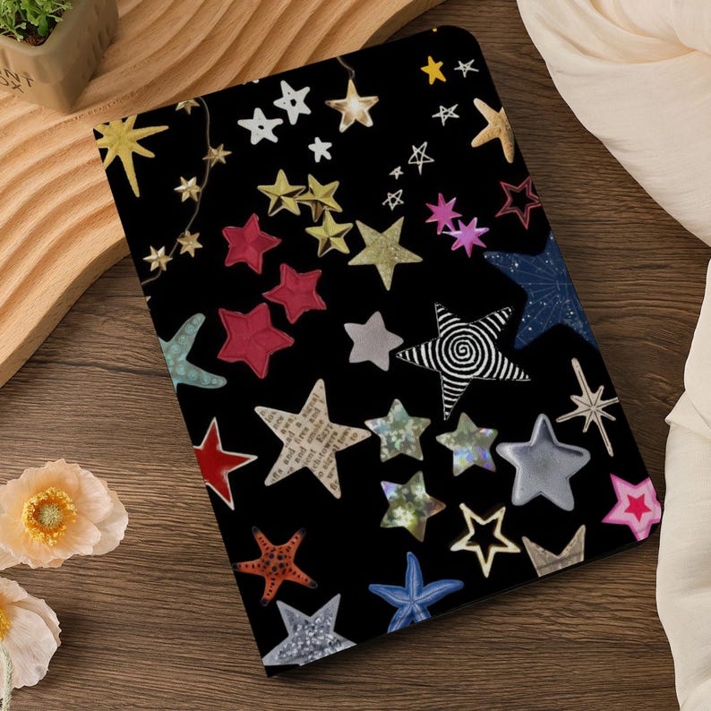 Pu&ograve; includere: Uno sfondo nero con una variet&agrave; di stelle colorate, tra cui rosso, oro, argento e blu. Le stelle sono di diverse dimensioni e forme, e alcune hanno un design a spirale. Lo sfondo &egrave; nero, e le stelle sono sparse casualmente.