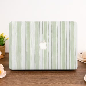 Könnte beinhalten: Eine Laptop-Hülle mit vertikalem Streifenmuster in Grün- und Weißtönen. Das Apple-Logo ist in der Mitte sichtbar. Die Hülle ist rechteckig und für einen Laptop konzipiert.