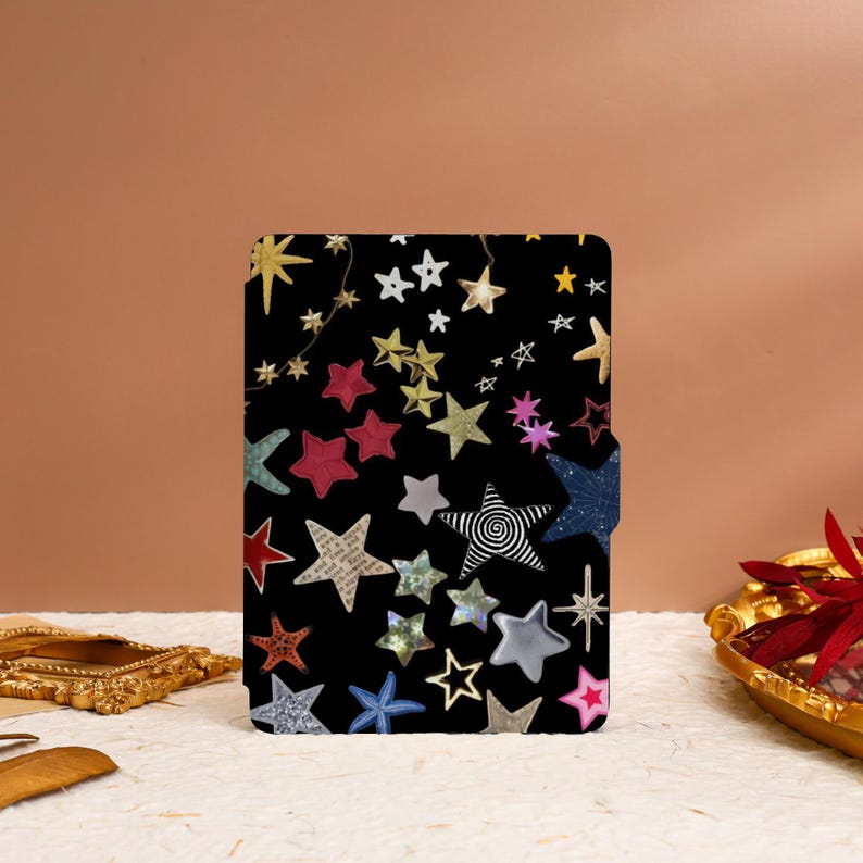 May include: A black case with a colorful star pattern. The stars are made of different materials, including glitter, paper, and fabric. The case is perfect for storing small items, such as jewelry or electronics.