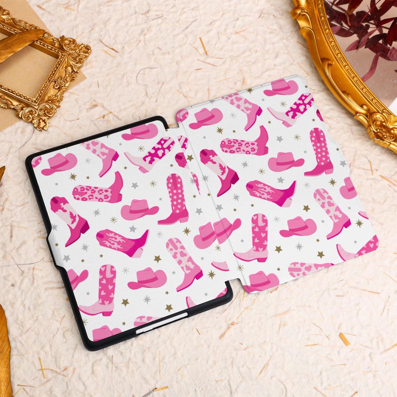 May include: A pink and white patterned Kindle cover with a design of cowboy boots and hats.