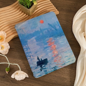 Könnte beinhalten: Ein blaues und rosa Gemälde einer Stadtlandschaft mit einer roten Sonne am Himmel und einem kleinen Boot im Wasser. Das Gemälde ist auf Leinwand und in einem schwarzen Rahmen gerahmt.
