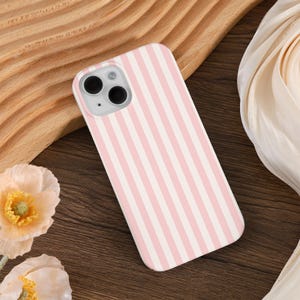 May include: A pink and white striped phone case for an iPhone 13 Pro Max.