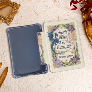 May include: A white and gold book cover with a blue and white dragon design. The title is "Fourth Wing: The Empyrean" by Rebecca Yarros.