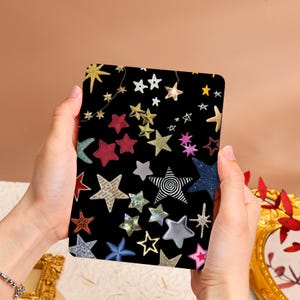 May include: A black e-reader cover with a colorful star pattern. The stars are in various colors, including red, gold, blue, and pink.