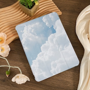 May include: A white and blue tablet case with a cloud pattern. The case is made of a soft, durable material and is designed to protect your tablet from scratches and bumps.