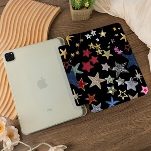 Pu&ograve; includere: Una custodia nera per iPad con un motivo a stelle colorate. La custodia presenta una variet&agrave; di stelle in diversi colori, dimensioni e forme, tra cui rosso, blu, giallo e verde. La custodia &egrave; progettata per adattarsi a un iPad.