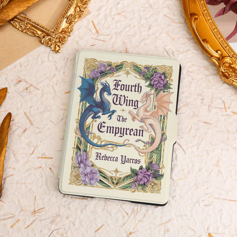 May include: A white e-reader cover with a gold and purple floral design. The cover features two dragons, one blue and one white, with the text "Fourth Wing The Empyrean" and "Rebecca Yarros".