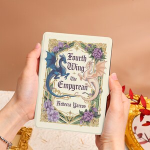 May include: A white Kindle Paperwhite e-reader cover with a floral design featuring two dragons. The cover has the title "Fourth Wing The Empyrean" and the author's name "Rebecca Yarros".