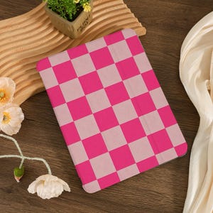 May include: A pink and white checkered iPad case. The case is made of a soft, textured material.