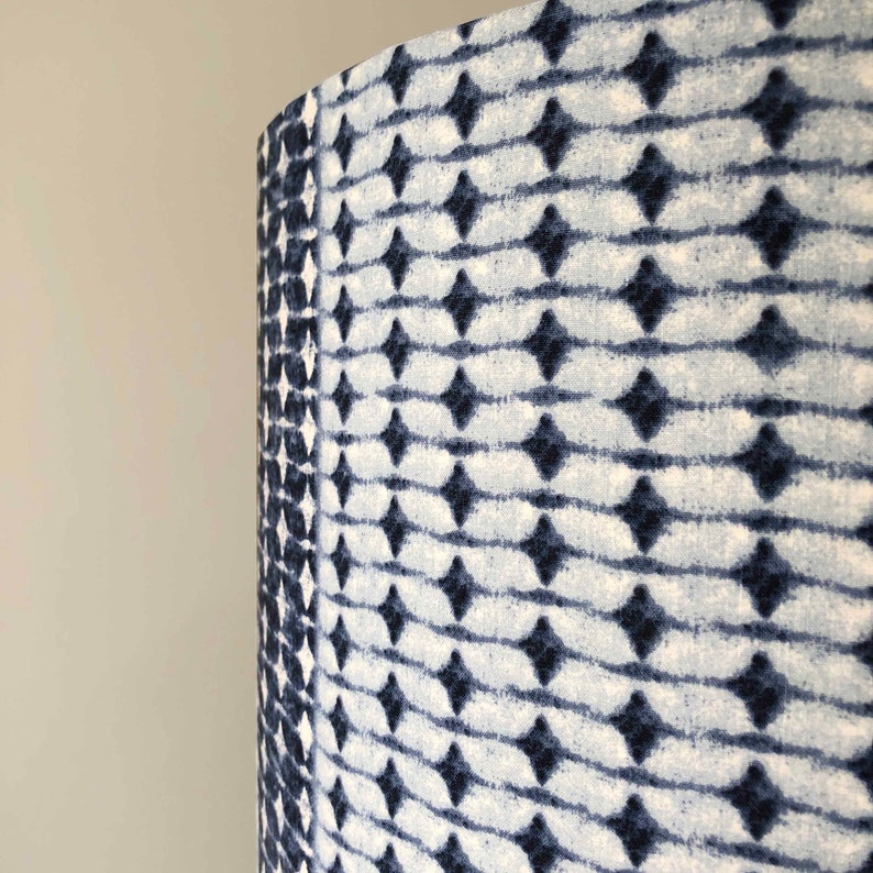 May include: A lampshade with a blue and white geometric pattern. The pattern is made up of small diamonds and lines.