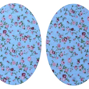 May include: Two oval-shaped fabric pieces with a light blue background and a repeating pattern of small pink and burgundy flowers with green stems.