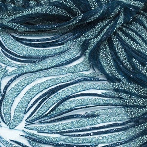 May include: Teal and blue beaded fabric with a wavy pattern. The fabric is made of a mesh material and is decorated with small beads.
