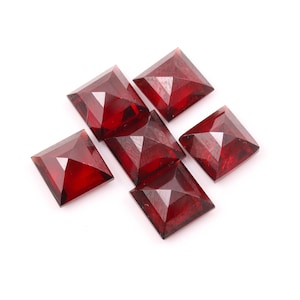 May include: Six red square-shaped gemstones with a faceted design.
