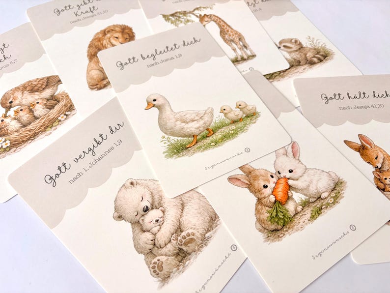 May include: A collection of illustrated cards featuring various animals, including a lion, giraffe, ducklings, and rabbits. Each card has a scalloped edge and text in German. The illustrations are in soft, muted colors.