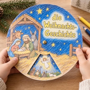 May include: A circular paper craft featuring a colored pencil illustration of a nativity scene with a stable, Mary, Joseph, and the baby Jesus. The text "die Weihnachts-Geschichte" is printed in yellow. A rotating wheel reveals an angel and shepherds.