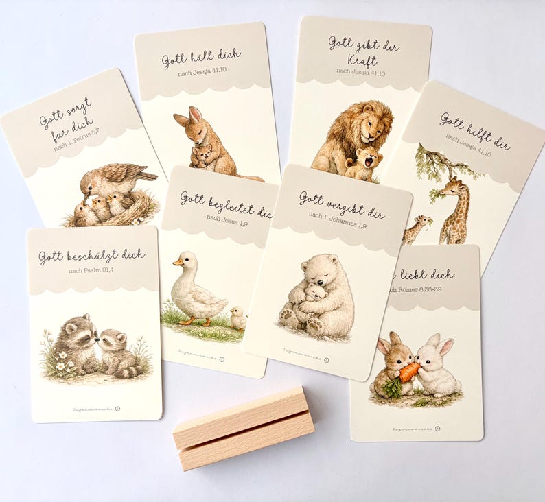 May include: A collection of illustrated cards with animal illustrations, including a bird with chicks, a rabbit with a baby rabbit, a lion with a cub, and a giraffe with a baby giraffe. Each card has German text.