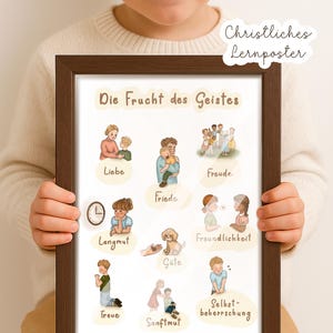 Könnte beinhalten: Ein gerahmtes Poster mit dem Text "Die Frucht des Geistes" und Illustrationen von Tugenden. Das Poster wird von einer Person gehalten, die einen cremefarbenen Pullover trägt. Das Poster enthält den Text "Christliches Lernposter".