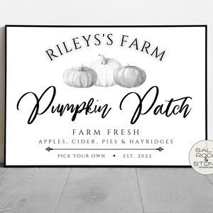 May include: Black and white sign with the text "Riley's Farm Pumpkin Patch" and the words "Farm Fresh Apples, Cider, Pies & Hayrides Pick Your Own Est. 2022". The sign features three black and white pumpkins.