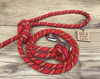 May include: Red, yellow, and blue rope dog leash with a silver clip and a wooden tag that says "DOG & Coast Planet Friendly Dog Boutique".