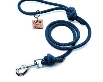 May include: A navy blue dog leash with a loop handle and a metal clasp. The leash is made of a thick, woven rope and features a wooden tag that reads "DOG & Coast Planet Friendly Dog Boutique."