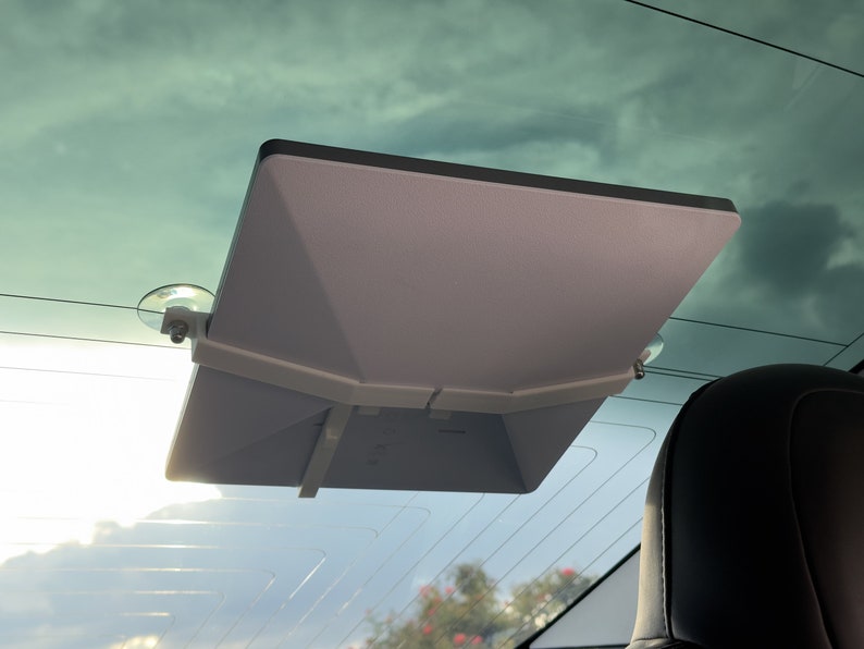 Peut inclure: Support de pare-brise de voiture blanc avec ventouses tenant une tablette blanche.