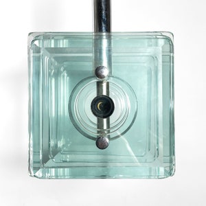 Peut inclure: Un luminaire de plafond carr&eacute; en verre avec une finition chrom&eacute;e et une seule ampoule. Le verre est transparent et pr&eacute;sente un design en couches.