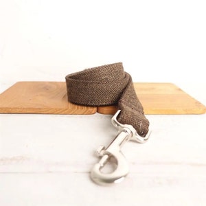 May include: A brown herringbone patterned dog leash with a silver metal clip.