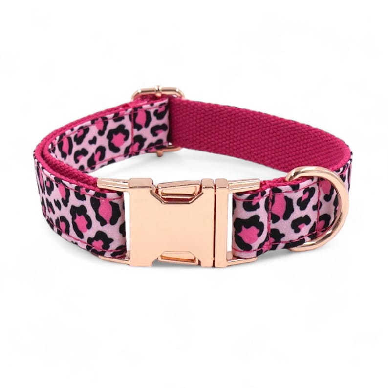 May include: A pink and black leopard print dog collar with a rose gold buckle and D-ring.
